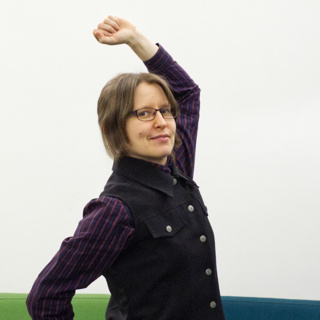 Woman making an uppercut punch gesture and smiling.
